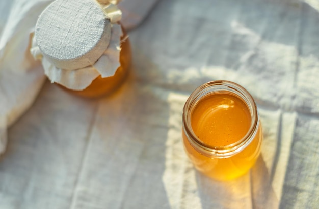 Deux boîtes de miel naturel. Du miel sur le tissu.