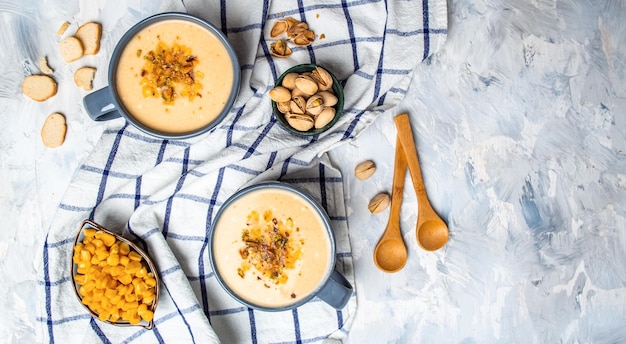 Deux bols de crème de soupe de maïs aux pistaches et croûtons sur l'image verticale supérieure Cuisine végétalienne Menu du restaurant recette de livre de recettes de régime