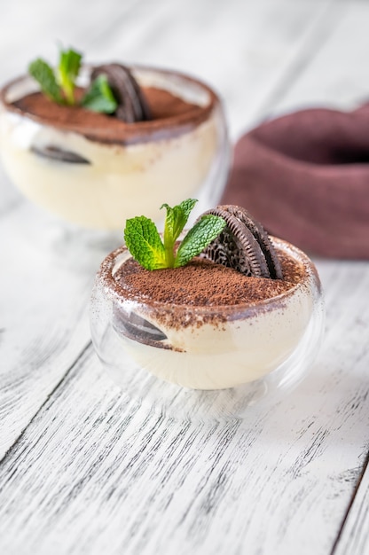 Deux bols en verre de dessert avec des biscuits et du fromage à la crème