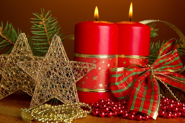 Deux bougies et décorations de Noël, sur fond marron