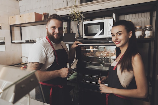 Deux boulangers professionnels se tiennent près du four.