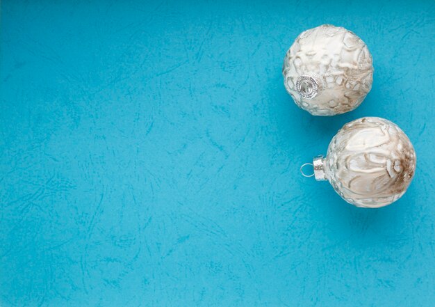 Deux boules de Noël blanches sur bleu. Mise à plat