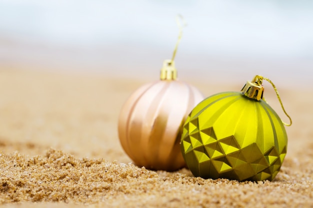 Deux boules de Noël sur le rivage sablonneux de l'océan