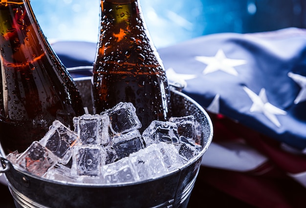 Deux Bouteilles De Bière Dans Un Seau à Glace Avec Le Drapeau Américain à Proximité. Concept De Célébration De La Fête De L'indépendance