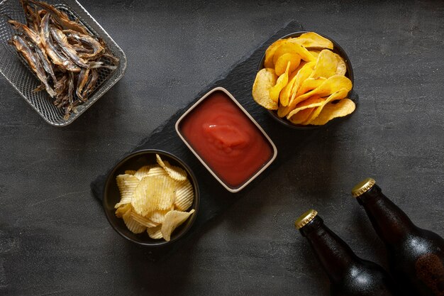 Deux bouteilles de bière avec frites, ketchup aux tomates et poisson séché