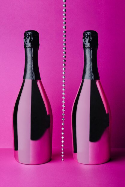 Deux bouteilles de champagne sur fond rose