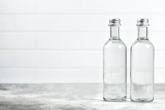 Deux bouteilles d'eau en verre sur fond gris Eau propre dans une bouteille Maquette Copier le texte de l'espace