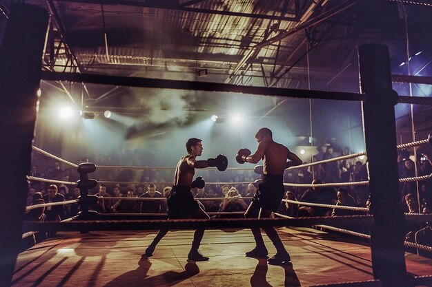 Photo deux boxeurs professionnels se battent dans le ring au gymnase.