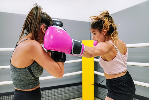 Deux boxeuses pratiquant la boxe sur le ring à la salle de gym