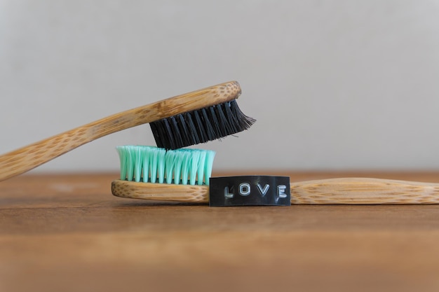 Deux brosses à dents l'une sur l'autre à côté du mot amour l'une sur l'autre à côté du mot amour