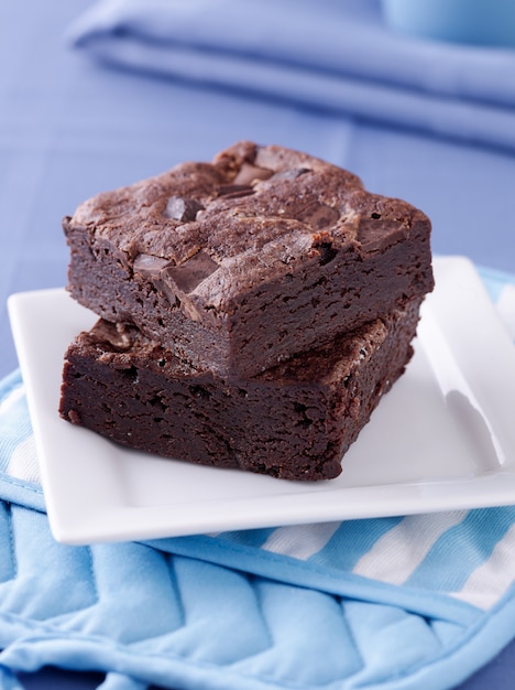 Deux brownies empilés sur une assiette.