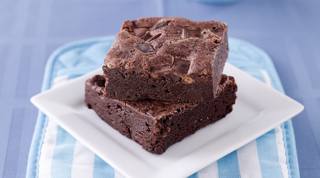 Deux brownies empilés sur une assiette.