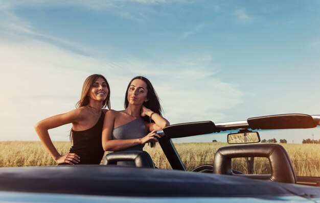 Deux, brunette, femmes, debout, près, voiture