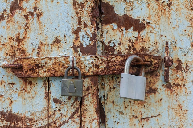 Deux cadenas sur une porte en métal rouillé