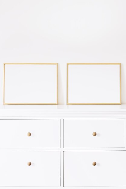 Deux cadres horizontaux dorés sur des meubles blancs