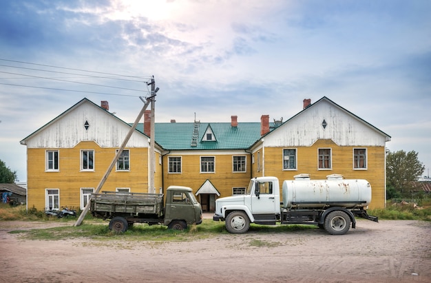 Deux camions se tiennent devant un immeuble résidentiel jaune sur les îles Solovetsky