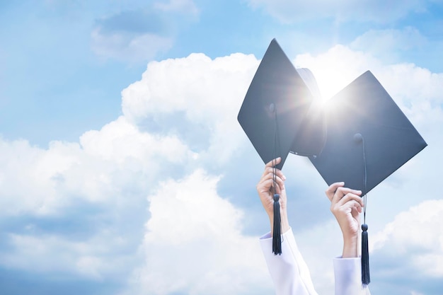 Deux casquettes de graduation sur le fond du ciel bleu