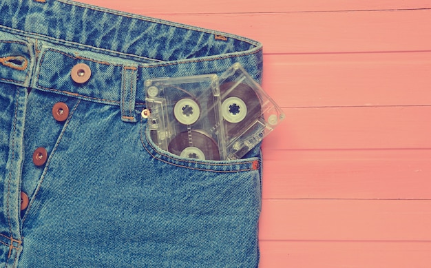 Deux Cassettes Audio Dans Une Poche De Jeans Sur Une Surface En Bois Rose