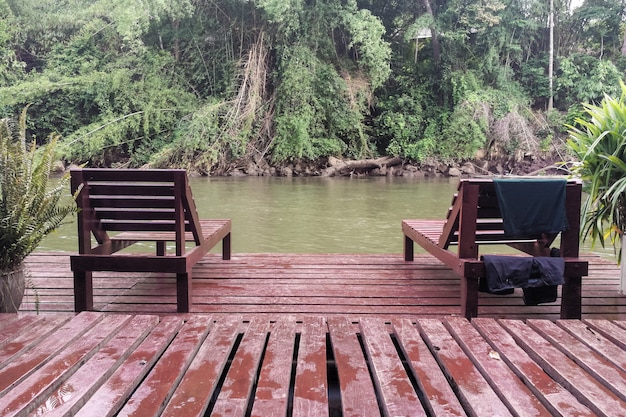 Deux chaises longues en bois marron sur la rivière