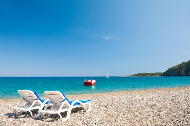 Deux chaises longues sur la plage de galets à Kemer, Turquie. Beau paysage d'été