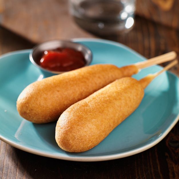 Deux chiens de maïs sur une assiette avec du ketchup