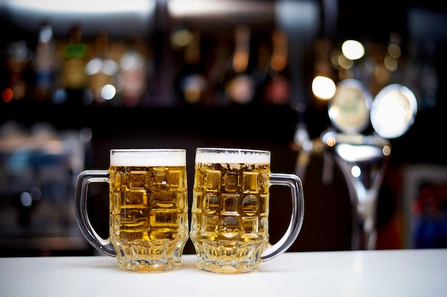 Deux chopes de bière froide se tiennent sur le bar.