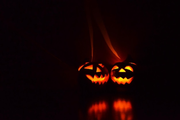 deux citrouilles d'halloween jack o lantern brillent dans le noir