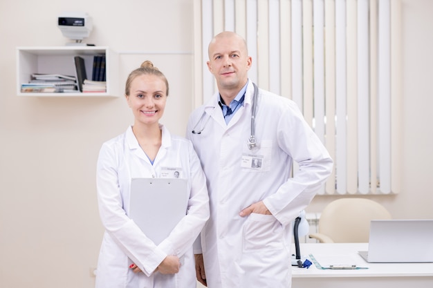 Deux cliniciens contemporains réussis en blanchons debout par lieu de travail au bureau