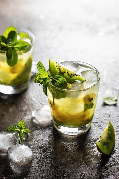 Deux cocktails glacés frais avec kiwi et menthe sur fond texturé