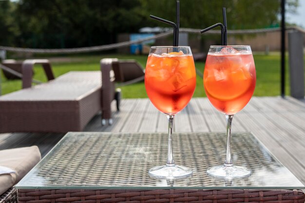 deux cocktails orange aperol sur une table au bord de la plage en été par une journée ensoleillée