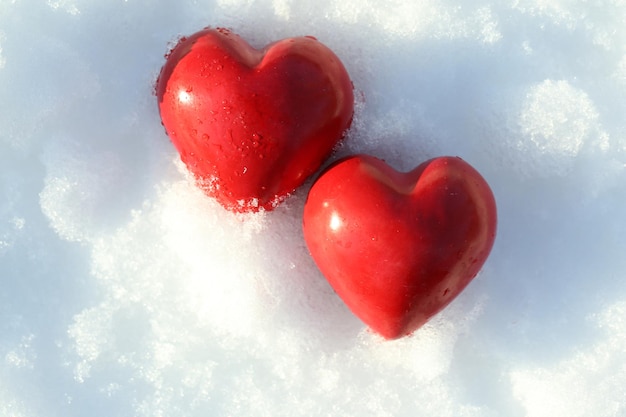 Deux coeur gelé rouge sur fond de neige