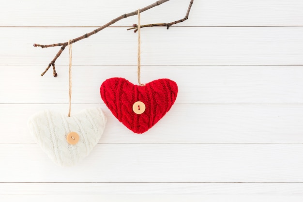 Deux coeurs sur une branche sur un fond en bois blanc. Concept de Saint Valentin.