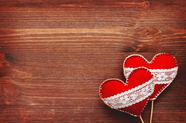 Photo deux coeurs en feutre avec lacets, symbole de l'amour sur bois