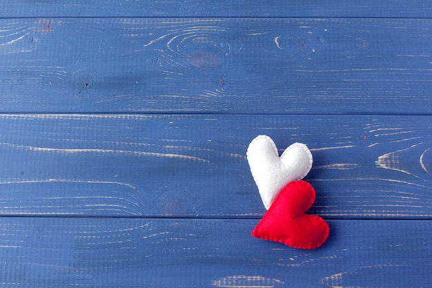 Deux coeurs en feutre rouge sur fond blanc. Symbole de la Saint-Valentin, concept de vacances. Vue de dessus avec espace de copie pour le texte.