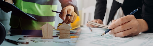 Deux collègues discutant du travail des données et d'un ordinateur portable avec une tablette sur un projet architectural sur un chantier de construction au bureau au bureau