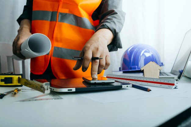 Deux collègues discutant du travail des données et d'un ordinateur portable avec une tablette sur un projet architectural sur un chantier de construction au bureau au bureau