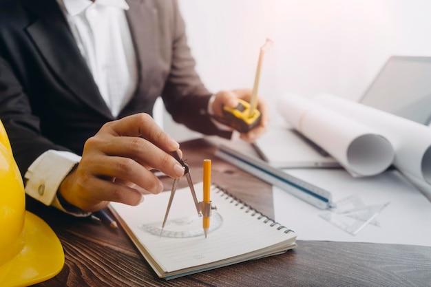 Deux collègues discutant du travail des données et d'un ordinateur portable avec une tablette sur un projet architectural sur un chantier de construction au bureau au bureau