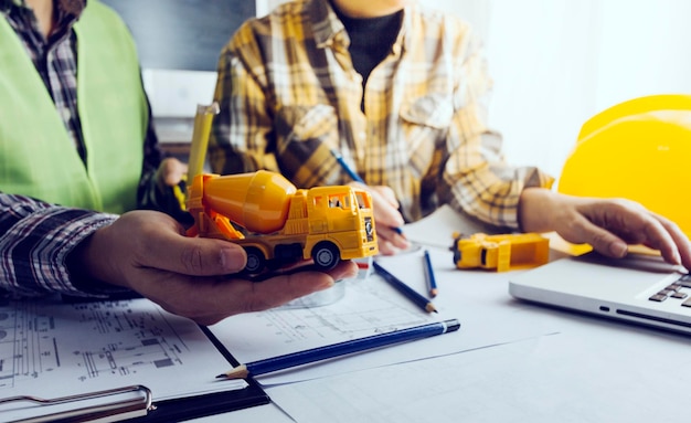 Deux collègues discutant du travail des données et d'un ordinateur portable avec une tablette sur un projet architectural sur un chantier de construction au bureau au bureau