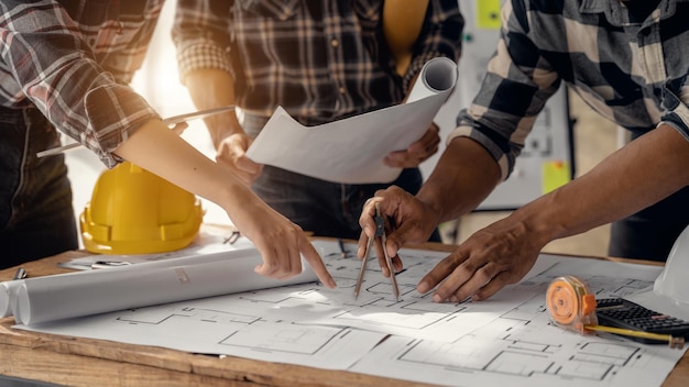 Deux collègues discutant du travail des données et d'un ordinateur portable avec une tablette sur un projet architectural sur un chantier de construction au bureau au bureau