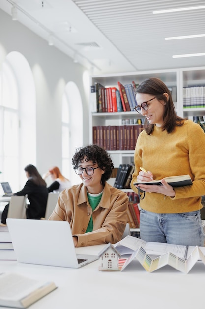 Deux collègues féminines travaillent sur des architectes concepteurs d'ordinateurs portables discutent du projet d'étudiantes réussies