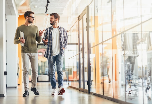 Deux collègues masculins discutant de quelque chose sur le chemin du travail