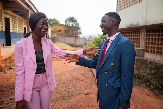 Deux collègues masculins et féminins rient lors d'une conversation des Africains au travail