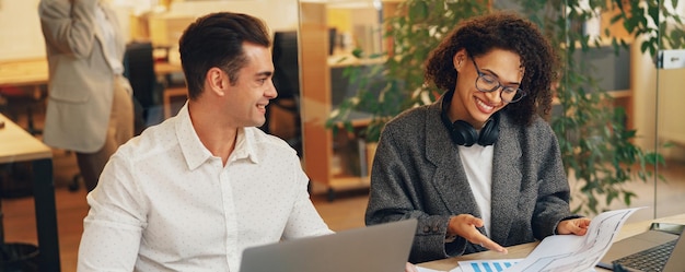 Deux collègues travaillant avec des documents assis au bureau Concept de travail d'équipe Photo de haute qualité