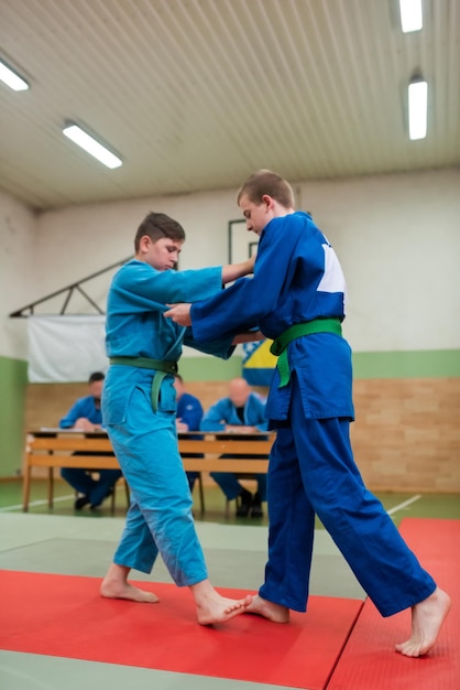 Deux combattants de judo montrant des compétences techniques tout en pratiquant les arts martiaux dans un club de combat Les deux hommes en forme en uniforme combattent le concept de compétition d'athlètes d'entraînement de karaté