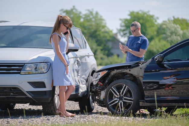 Deux conducteurs parlent au téléphone mobile tout en appelant à l'aide pour secourir les services dans un accident de voiture. Concept de sécurité routière et d'assurance.