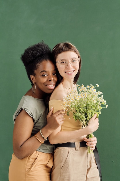 Deux copines affectueuses mignonnes regardant la caméra