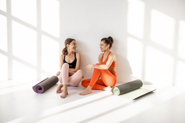 Deux copines discutent lors d'une pause yoga à l'intérieur