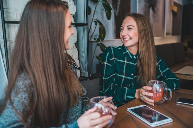 Deux copines parlent au café tout en buvant un thé