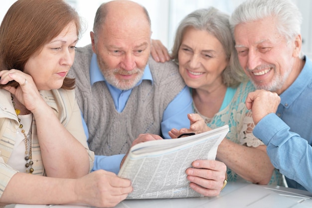 Deux couples âgés lisant le journal