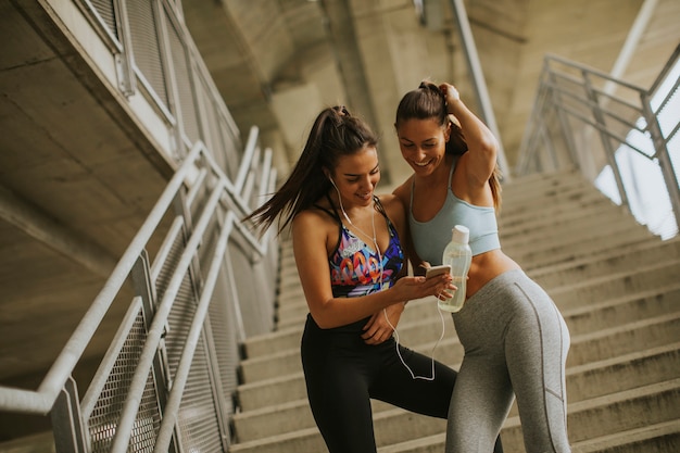 Deux coureuses à la recherche d&#39;un smartphone se reposent après le jogging